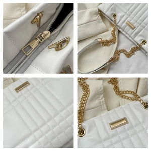Close-up of white quilted leather bag with gold-tone hardware and chain strap details