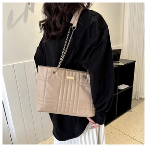 Close-up of beige quilted PU leather tote bag featuring gold chain strap and metal hardware