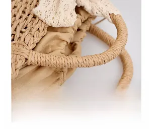Detailed view of woven straw handbag handle with lace trim and cotton lining
