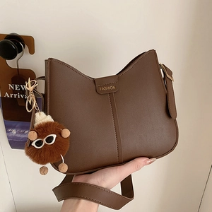 Retro dark brown large capacity crossbody bag with fashion label and plush doll charm