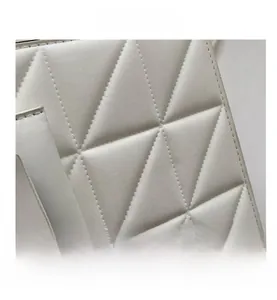 Detailed macro view of white quilted faux leather texture and gold metal ring hardware