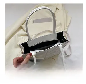 Detail showing internal compartments and large capacity of the white quilted tote bag