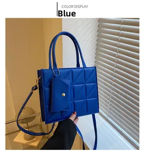 Detail of blue square box handbag with geometric quilted pattern and coin pouch