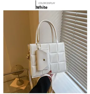 Detailed view of a white quilted square handbag with a matching mini envelope pouch attachment