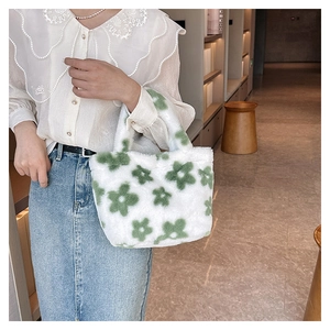 Detail of white plush tote bag with green floral pattern showing soft fuzzy texture