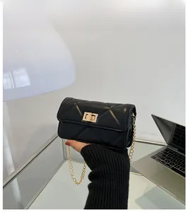 Close-up of black quilted leather chain bag with gold rectangular twist lock mechanism