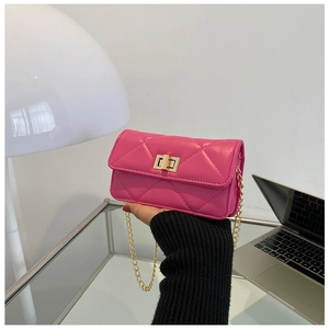Detail of rose red quilted crossbody bag with gold metal twist lock and chain strap