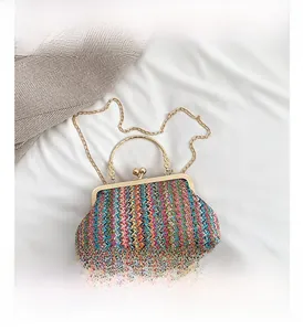 Detail of bohemian woven shell bag with gold ring handles and colorful geometric patterns