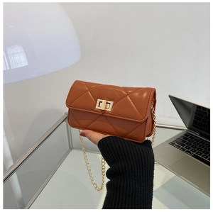Detailed close-up of brown quilted chain bag with elegant gold metal twist lock