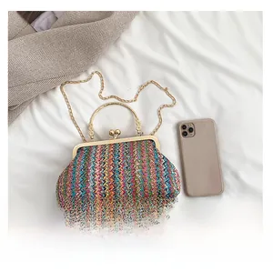 Detail of colorful woven handbag with gold metal clasp and chain shoulder strap