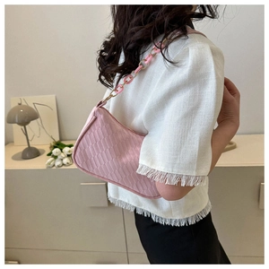 Detail view of pink woven texture underarm bag with stylish resin and chain shoulder strap