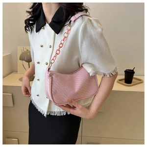 Pink woven leather baguette bag with dual-tone metal and acrylic chain strap detail