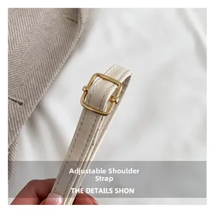 Detail of adjustable off-white leather strap with gold metal buckle and fine stitching