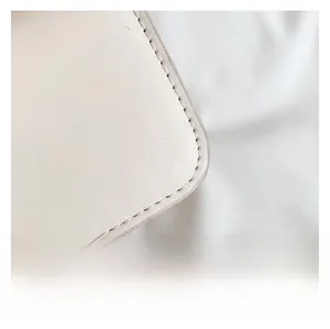 Macro detail of high-quality cream leather crescent bag with precise stitching