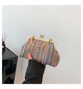 Detail of colorful wavy woven clutch with vintage gold metal frame and kiss-lock closure