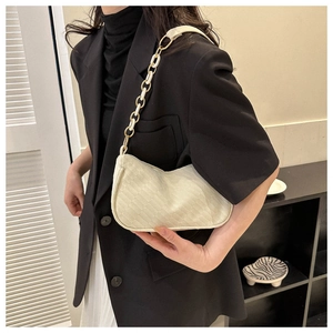 Detail of cream woven shoulder bag featuring quilted PU leather and metal chain strap