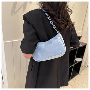 Detail of light blue faux crocodile baguette bag with matching chunky chain strap