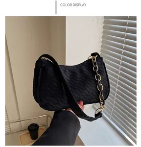 Detail of black checkered shoulder bag featuring a dual chain and fabric strap design