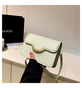 Detail of mint green square crossbody bag with gold metal lock and leather texture