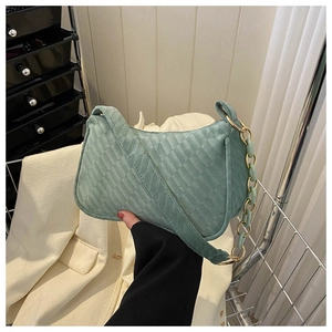 Close-up of green checkered textured baguette bag with gold chain strap detail