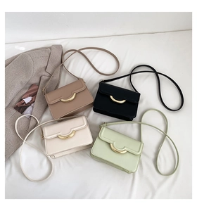 Detail view of small square crossbody bags in khaki, black, cream and green smooth PU leather