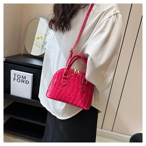 Detail of flamingo pink crocodile embossed shell bag with metallic double zipper closure