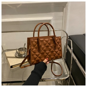 Detailed macro of brown leather handbag featuring unique 3D heart embossed textures