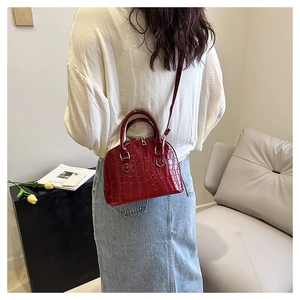 Model wearing dark red crocodile pattern shell bag with modern casual lifestyle background