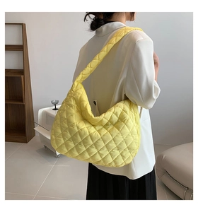 Detail of bright yellow quilted hobo bag with large capacity and soft nylon texture