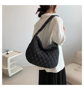 Close-up of quilted black tote bag showing detailed diamond patterns and padded nylon texture