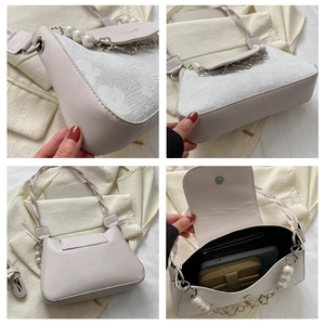 Detail of cream shoulder bag with floral jacquard, pearl beads, and interior storage view