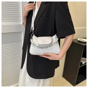 Detailed view of white lace embroidered shoulder bag with pearl and floral chain strap