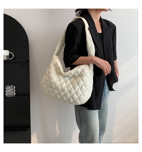 Side view of white quilted puffer shoulder bag with stylish natural blind shadows