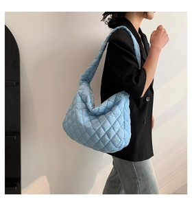 Detailed view of light blue quilted tote bag with diamond stitching and puffer texture