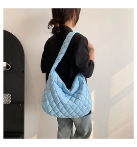Close-up of sky blue quilted tote bag with diamond lattice pattern and wide shoulder strap