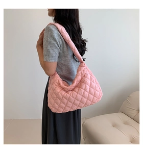 Close-up of pink quilted tote bag showing soft texture and padded shoulder strap