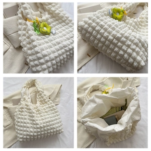 White puffer tote bag internal view with green flower charm showing spacious capacity
