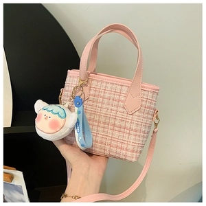 Dettaglio borsa a secchiello in tweed rosa con ciondolo carino e cinturino 'Sweet'