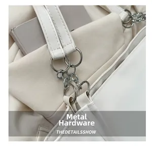 Detailed close-up of high-quality silver metal hardware and white leather tote handle