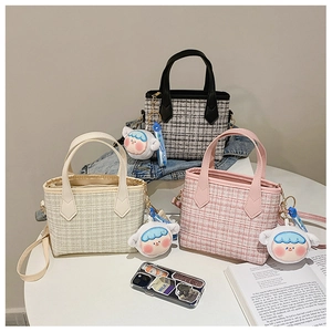 Dettaglio di mini borse a secchiello in tweed a quadri, beige e rosa con ciondoli a bambola