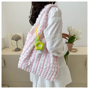Detail of pink and white popcorn texture tote bag with yellow flower charm