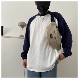 Detail view of the beige canvas chest bag with adjustable strap and fashion patch