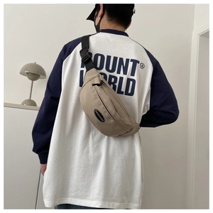 Khaki canvas crossbody bag with adjustable black strap and fashion logo on casual model