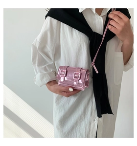 Close-up of a mini bright pink metallic Cambridge crossbody bag on a female model
