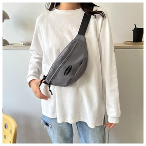 Close-up of gray nylon waist bag featuring a black Fashion logo and adjustable strap