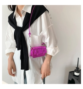 Mini metallic pink satchel bag with silver buckles and acrylic chain shown on model