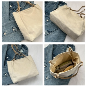 Detail showing the large capacity and rhombus texture of this cream white tote bag