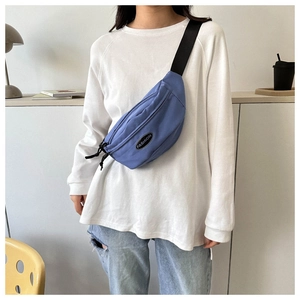 Blue nylon crossbody bag worn by a model, featuring an adjustable black shoulder strap