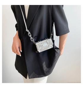 Chic silver mini satchel bag with transparent acrylic chain worn over a black blazer