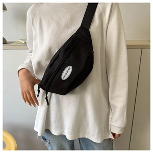 Detail of black canvas crossbody bag with adjustable strap and fashion logo